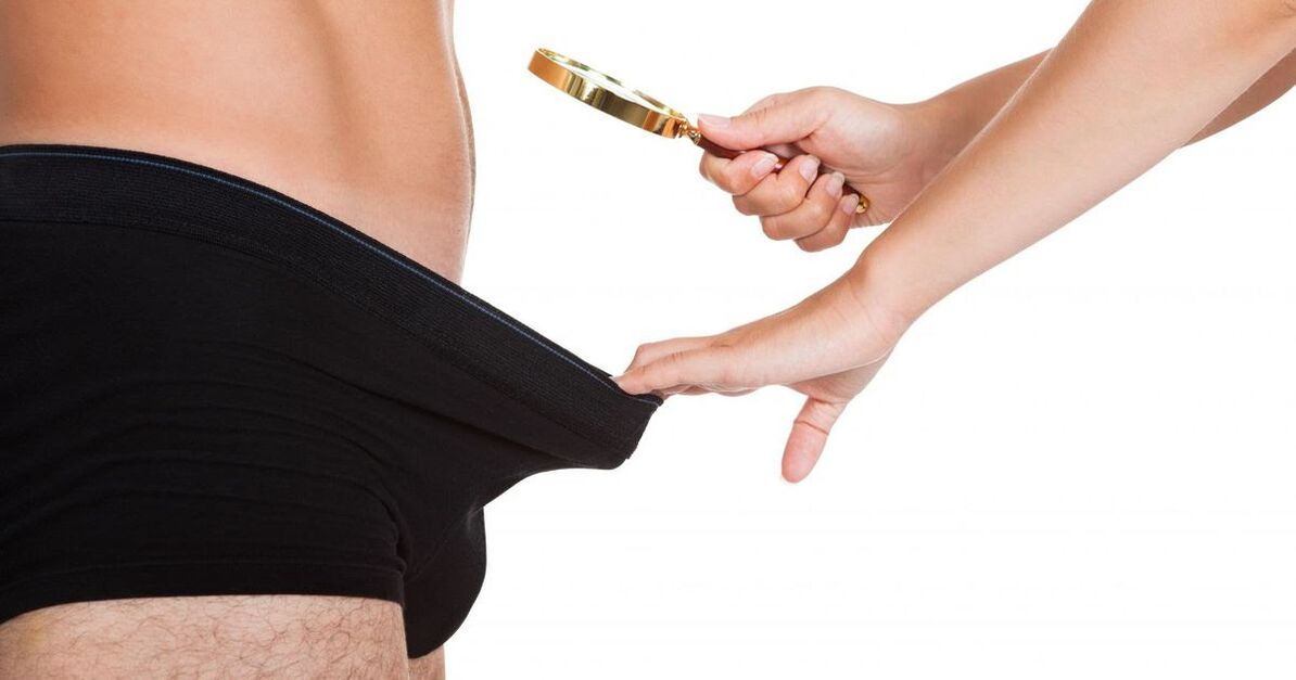 O fată se uită la un mic penis printr -o lupă